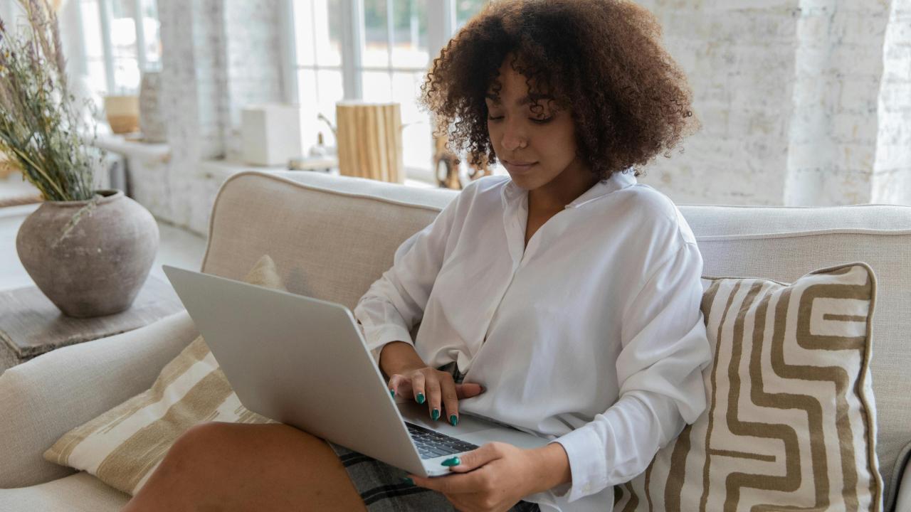 Person sitting in a living room, using a laptop