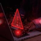 Decorative graphic with a laptop and a warning sign with an exclamation point