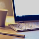 coffee cup, stylus and computer on a desk