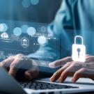 Zoomed in image of man typer on computer with a blue cast over the image and a lock icon on top