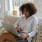 Person sitting in a living room, using a laptop