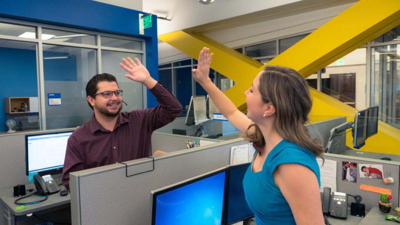 UCPath Center employees smiling and high-fiving