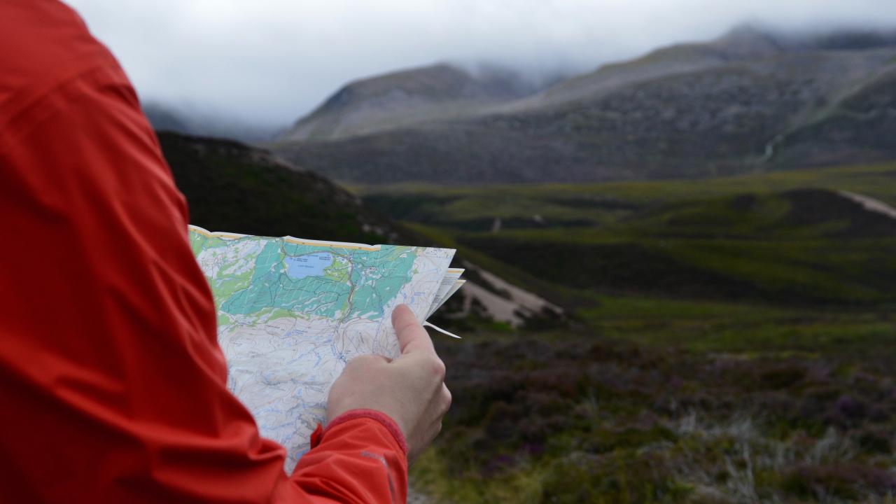 Hiker holding a map in the mountains