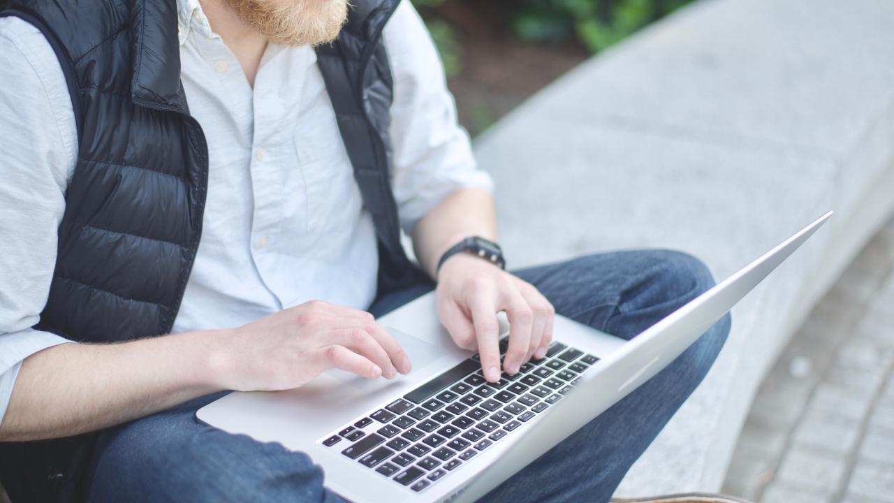 Person sitting outside with a laptop